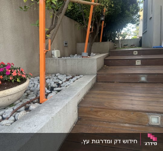 מדרגות עץ עם מעקה כתום ועצים מסביב